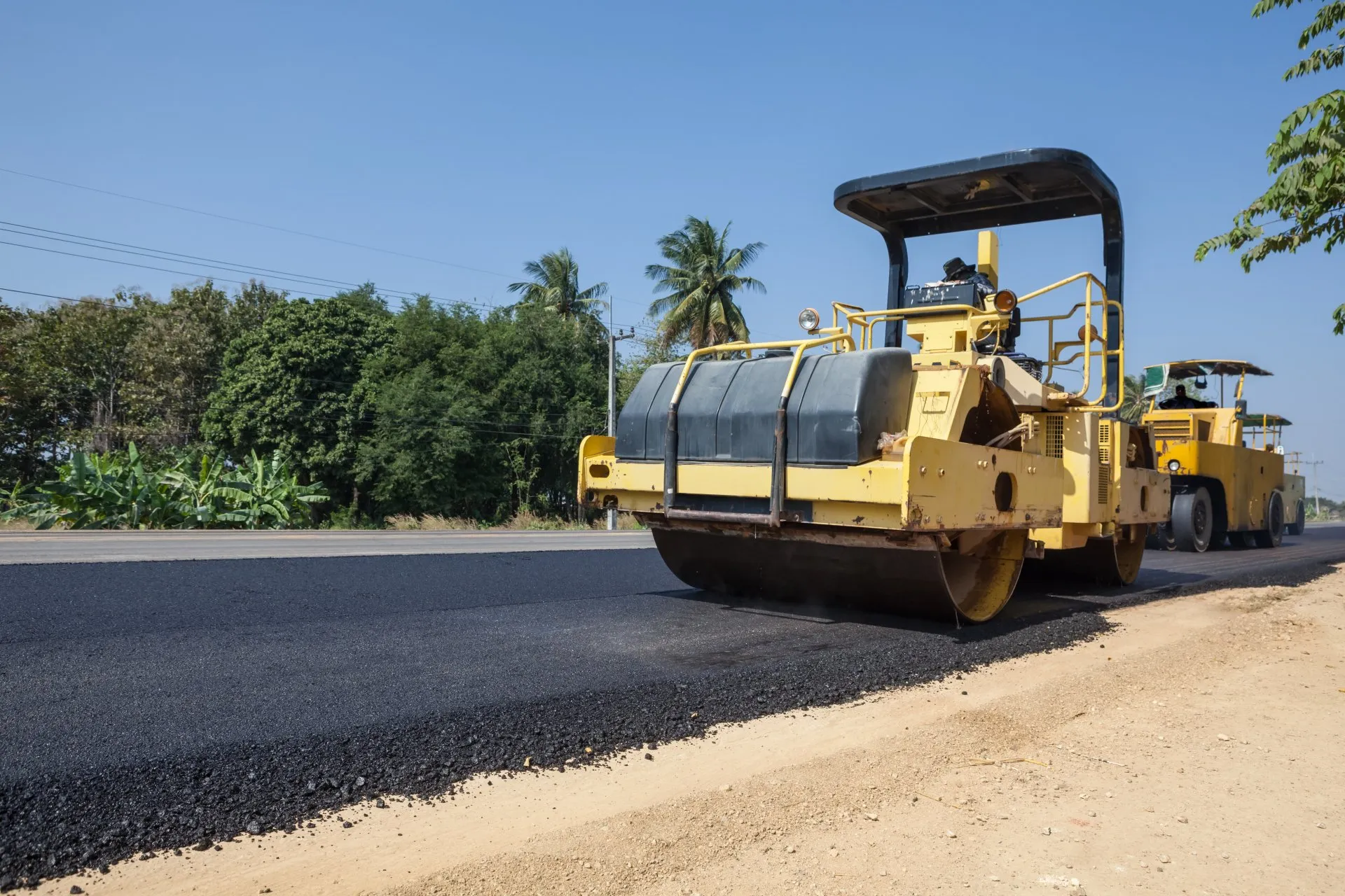 New asphalt road being rolled with large roller in jacksonville
