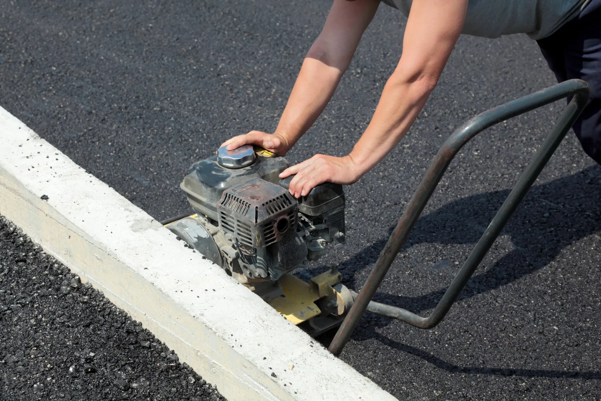 Asphalt contractor compacting edges of asphalt parking lot in jacksonville, fl